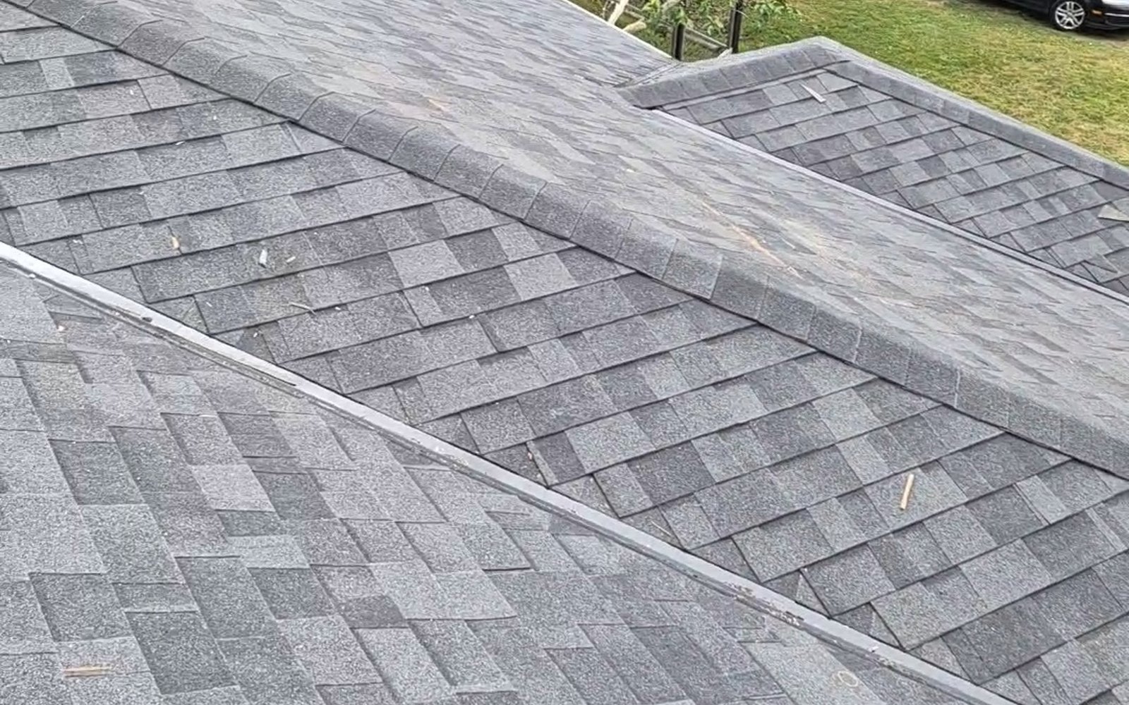 Completed gray shingle roof with intersecting slopes