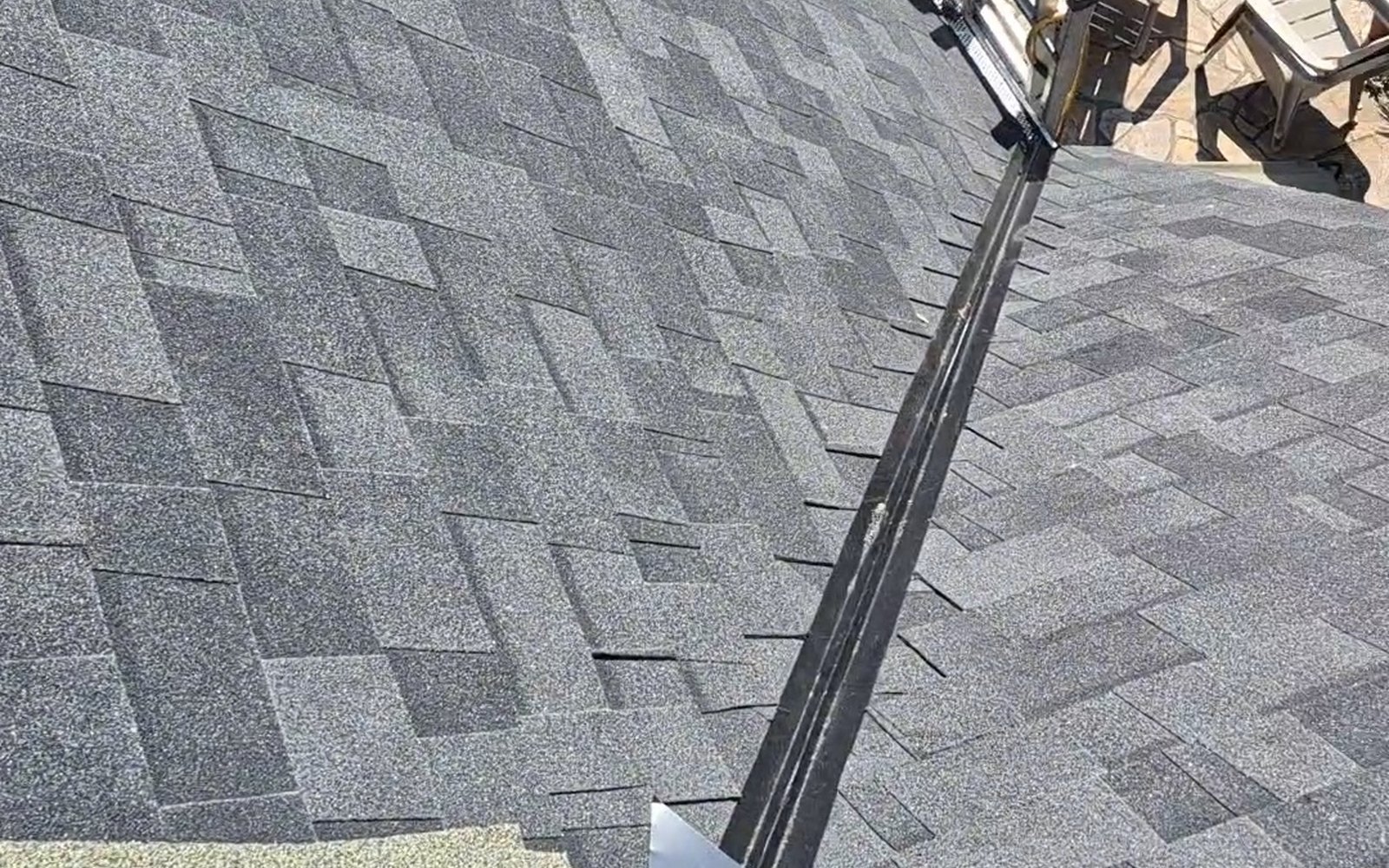 Gray shingle roof valley with metal flashing