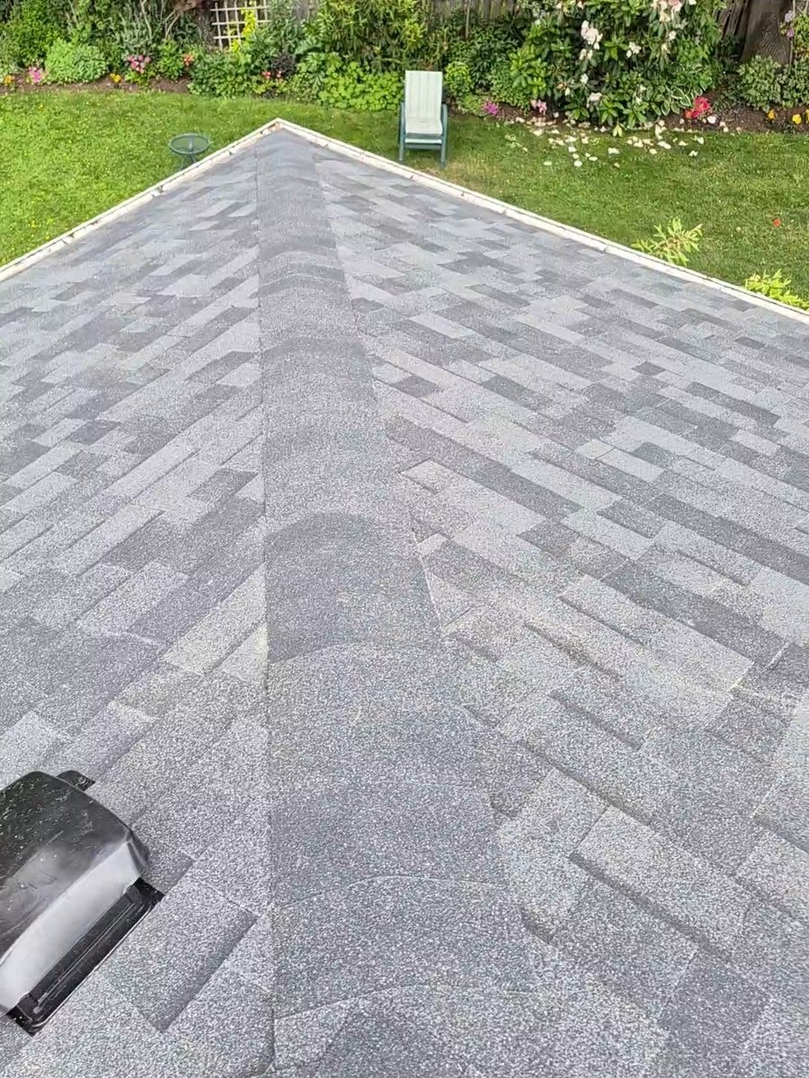 Finished gray shingle roof ridge viewed from above