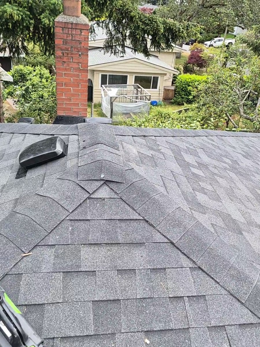 Gray shingle roof with brick chimney and roof vent