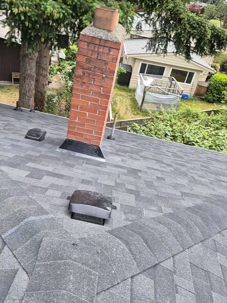 Brick chimney, roof vent and finished gray shingles