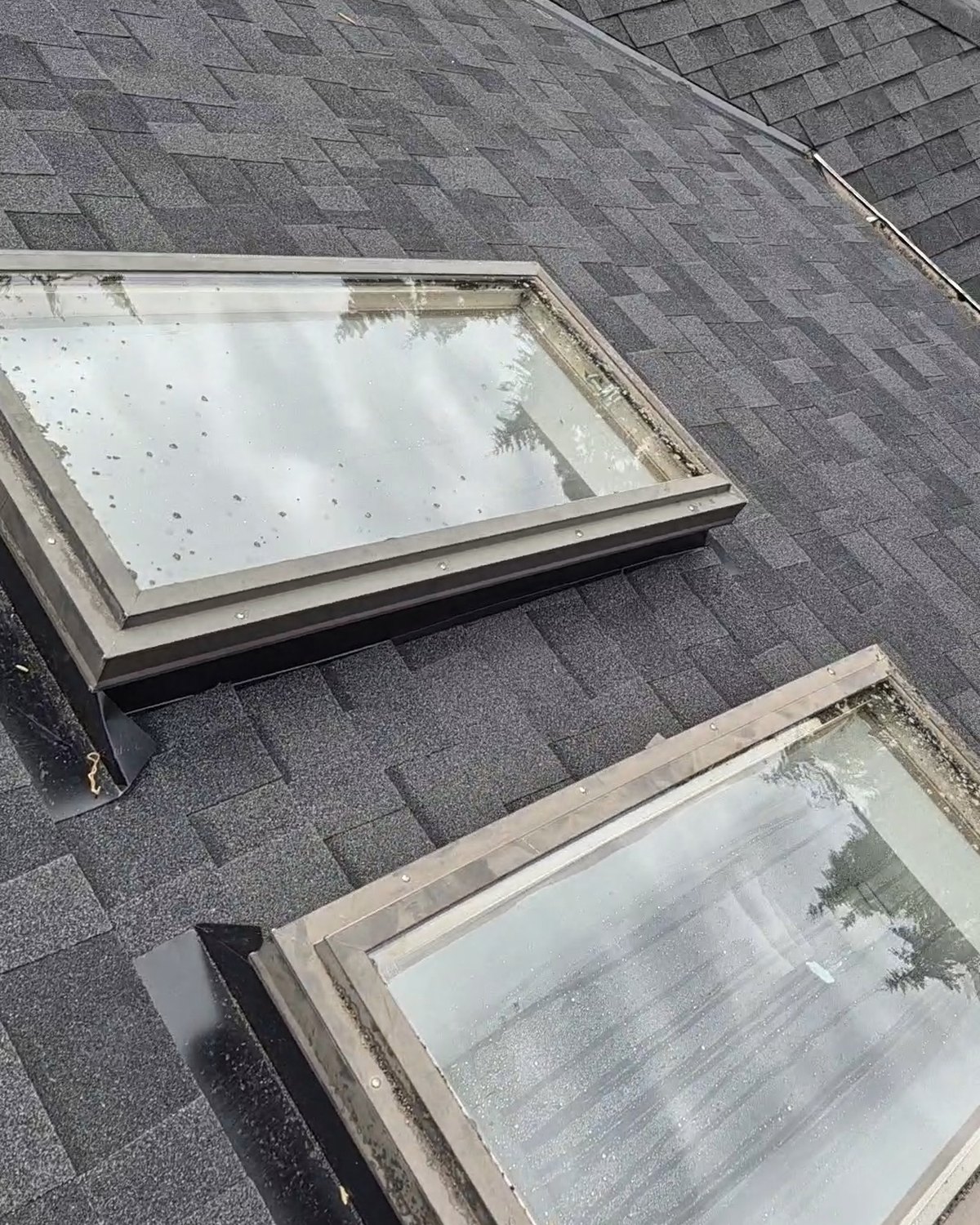 Two skylights fitted into a gray shingle roof
